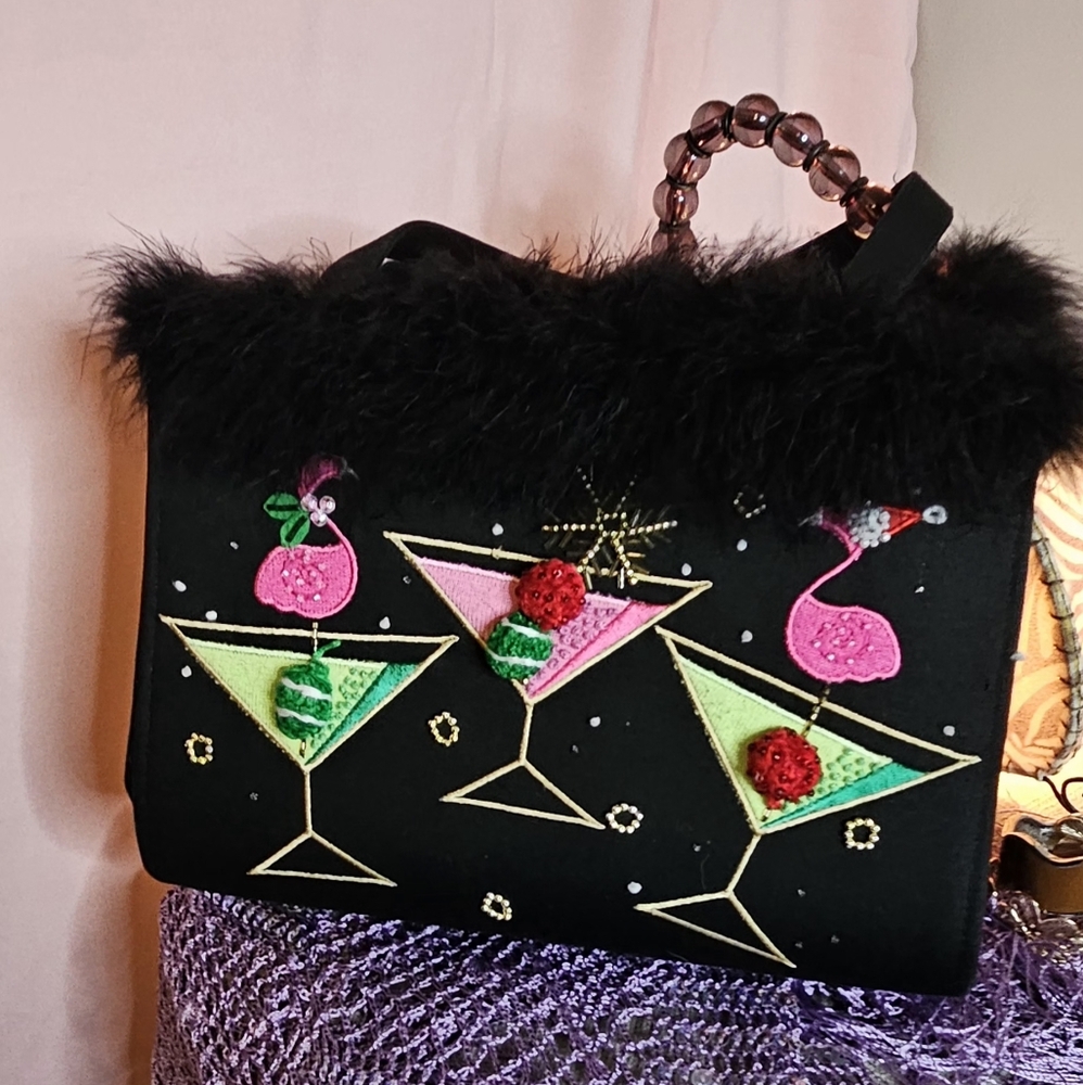 A sophisticated black evening shoulder bag adorned with feathers.